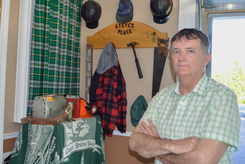 Steve Drake of New Waterford looks over a corner in his garage where he has a memorial to his coal miner father, the late Steve Drake Sr., that includes his father’s favourite lumberjack shirt, work cap, hard hat and some tools, together with some of his own former coal mining equipment.