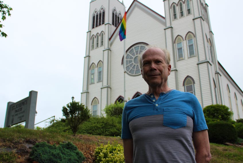 Father Peter McLeod stands outside St. Joseph’s Parish in Little Bras d’Or, the Catholic church he has presided over for the past 12 years. Behind him is the Pride flag, flying in support of the LGBTQ community. It was put up by two congregation members who asked to have the flag flying. McLeod said it is primarily a sign that this church is “open” and “welcoming” to all.