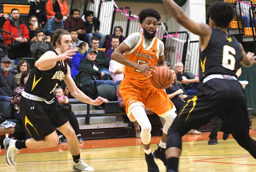 Osman Omar of the Cape Breton Capers, middle, works his way to the basket in this file photo during Atlantic University Sport men’s basketball action at Sullivan Field House in Sydney last season. Omar is among three returning players from last year’s team that posted a 2-18 record.