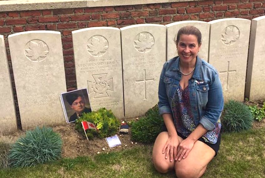 Lynzee MacNeil, a Grade 3 teacher at John Bernard Croak School in Glace Bay, kneels by the gravesite of the First World War hero John Bernard Croak at the Hangard Wood British Cemetery in France. SUBMITTED PHOTO