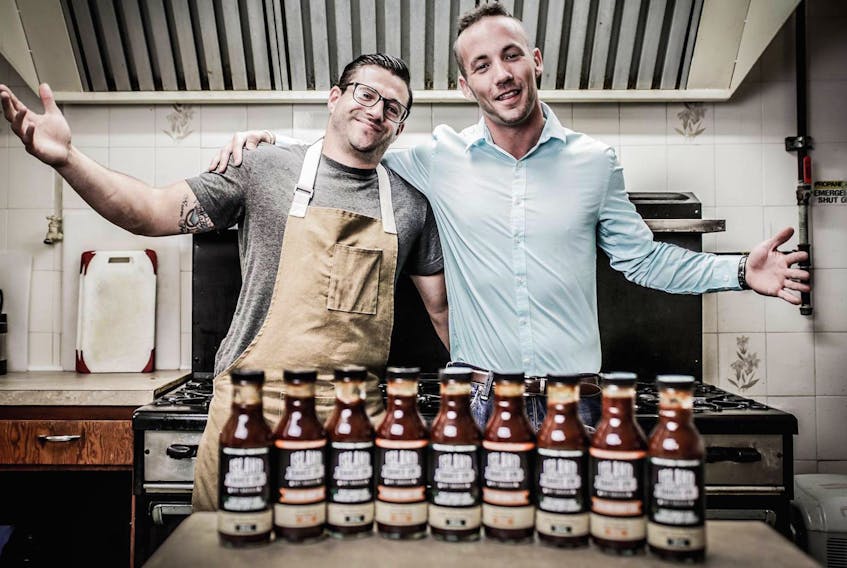 Island Sauce Company business partners Nathan Susin, left, and Keven Taylor, pose with jars of their sauce at the Polish Village Hall in Whitney Pier.
