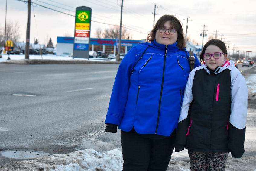 Kim Wells stands beside her 10-year-old daughter, Blayre, at the intersection of Reeves and Welton streets in Sydney. They live in the area and Wells says trying to use the crosswalk to get to the other side of the street is “dreadful.”