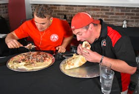 Sydney resident Joel Hansen, left, and professional eater and bodybuilder Randy Santel chow down during their attempt to successfully eat a six-pound donair in less than 28 minutes and 30 seconds, the time it took Hansen to complete the task in May. With an encouraging crowd looking on, Hansen devoured his donair in 14 minutes and 39 seconds, while Santel gobbled the last of his meal down five seconds later.