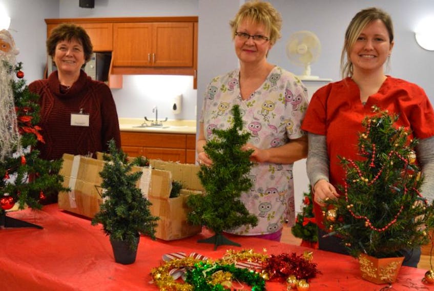 Staff of the Northside Community Guest Home makes sure every resident has a Christmas tree to brighten their room for the holiday season. Recreation director Kelly Carter and staff Tina Swain and Courtney Dearing decorate the last of the trees.