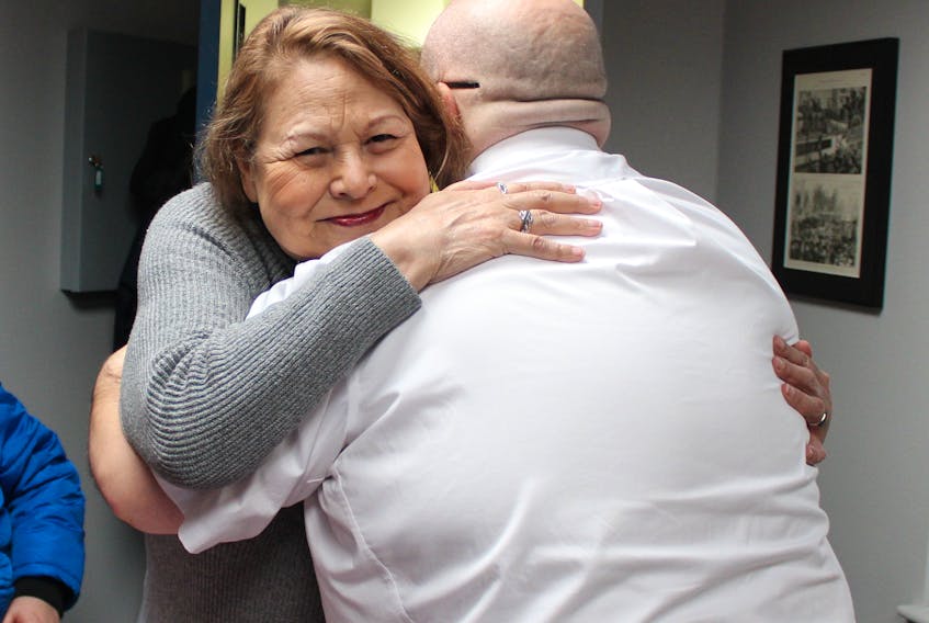 Rosemarie Woods hugs Maj. Corey Vincent on Tuesday morning after giving the Salvation Army a $10,000 donation. Woods was a ServiCom Call Centre employee when the Salvation Army offered her assistance last year. The donation was her thank you.