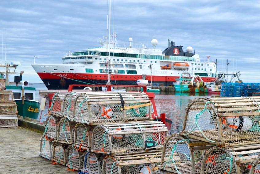 The MS Fram is shown here among the fishing boats and lobster traps of Louisbourg harbour on Friday. The cruise ship arrived in Louisbourg for about six hours, adding a contrasting view to the usual watercraft found along the docks.