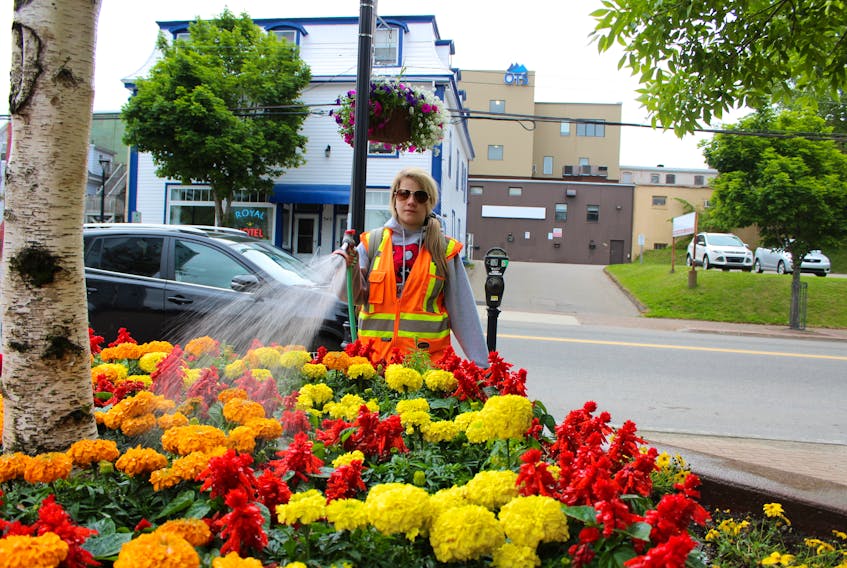 It takes a lot of effort to keep the flowers in front of the Cape Breton Regional Municipality's civic centre  bright and colourful throughout the summer. Sarah Jean Lohnes is among those who perform that job. The CBRM summer employee is shown watering the flowers early on Thursday morning.