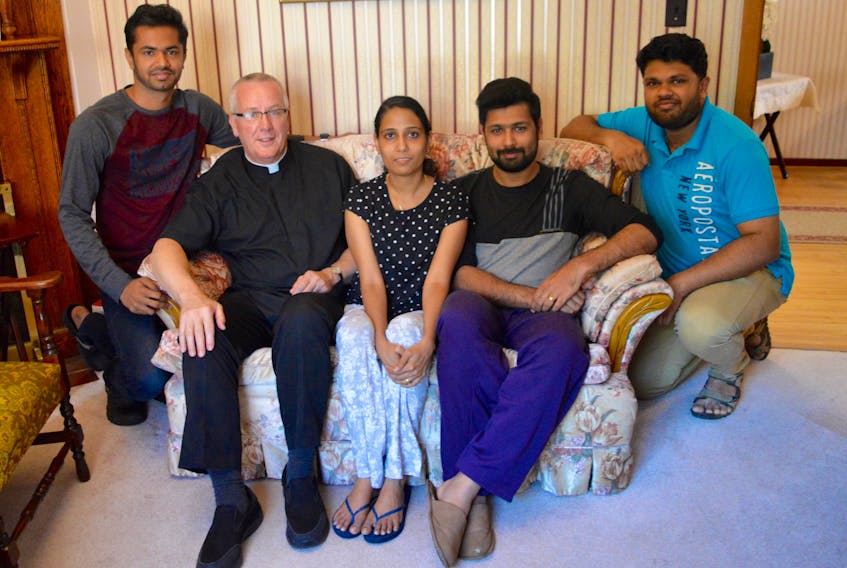 Seeing a lack of suitable accommodation for the many newcomers who recently arrived in Cape Breton from abroad, Rev. Paul Murphy opened up his home, in this case his rectory, to four 20-somethings from India. From left: Peter James, Rev. Murphy, Binolin Baby, who is pregnant, her husband Aby Abraham and Akhil John. All of Murphy’s new housemates are Catholic and grew up in a part of southern India where Christianity has been alive since Thomas the Apostle traveled there after the death of Jesus Christ.