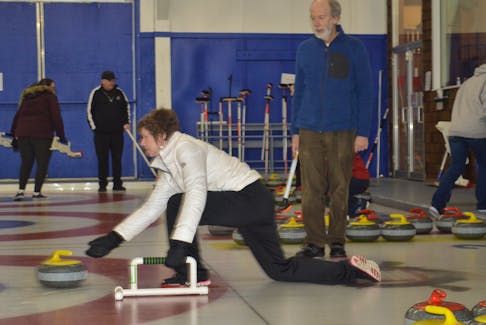 Cynthia Boutilier is taught how to curl by Ron Labelle during the Taste of Winter: Learn to Curl event at the Sydney Curling Club on Saturday.