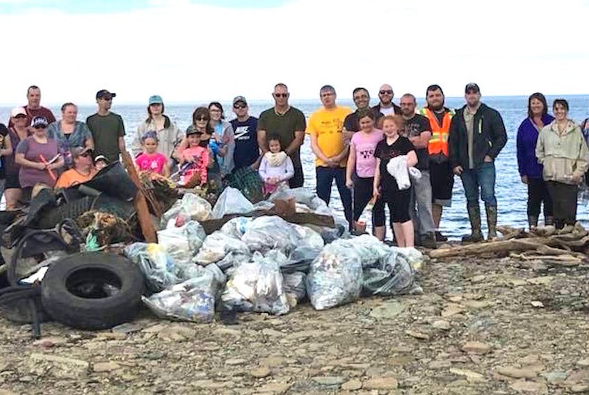 Volunteers are shown with debris they picked up after a community cleanup of Bridgeport beach Saturday. Less than two hours later, an illegal dump pile was discovered there.