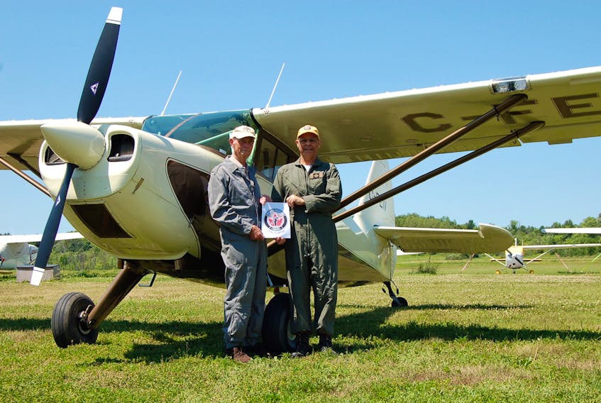 Flight engineer Terry Peters, left, stands with pilot Oliver Javanpour beside the latter’s Stinson 108 vintage aircraft. The pair is expected to land in Sydney on Friday to complete a cross-Canada journey in honour of the men and women who served their country.