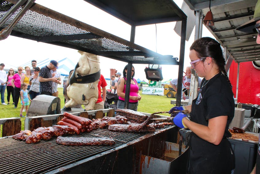 Camp 31’s Kelsey Brumm puts the finishing touch on racks of ribs, chicken and sausages on opening day of Rotary Rifest at Open Hearth Park in Sydney. Camp 31 ribbers were joined by counterparts from Silver Bullet, Texas Rangers, Billy Bones BBQ and Crabby’s BBQ Shack. The ribfest continues with food, music and activities on Saturday from 11 a.m. until 11 p.m. and Sunday from 11 a.m. until 7 p.m.