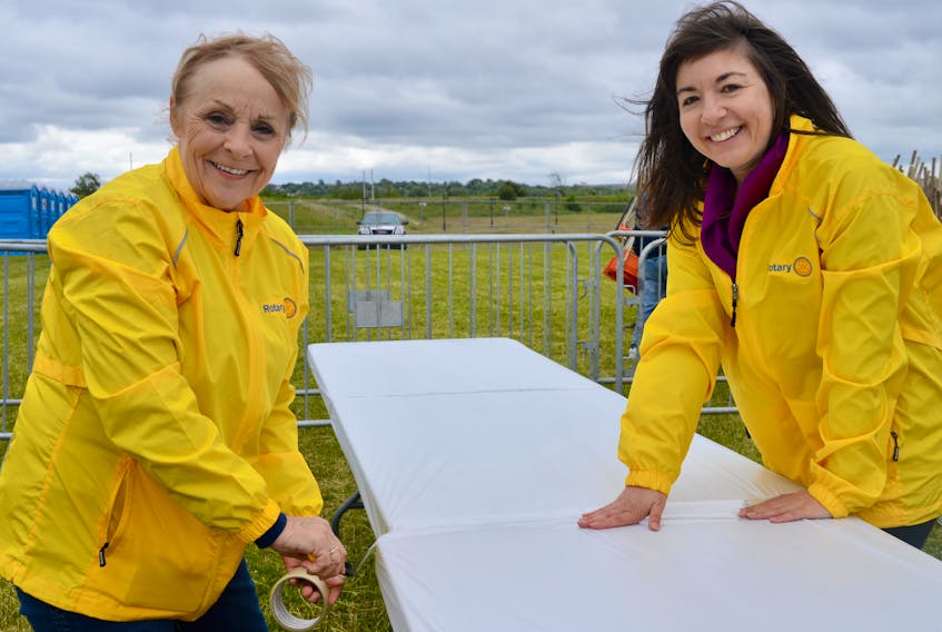Volunteers Linda MacMillan, left, and Tanya Hardy, both members of the Rotary Club of North Sydney, were busy wrapping tables on the Ribfest Grounds at Sydney’s Open Hearth Park on Thursday, in preparation for this weekend’s Rotary Ribfest event opening today (Friday).