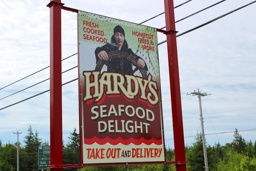 The sign for Hardy's Seafood Delight on Mira Road a few days before it was taken down. Owner Kevin Hardy, pictured in the sign, says the Cape Breton Regional Municipality isn't doing enough to help small businesses stay afloat.