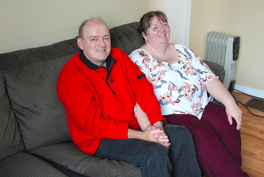Gordon MacNeil (left) and his wife Debbie sit on the sofa in the living room of their Glace Bay home on Sept. 11. Dedicated to helping their community, Gordon got Debbie involved in the Alzheimer’s Café’s he co-ordinates annually at the Mayflower Mall shortly after they met. The self-taught musician wanted to help educate people about Alzheimer’s disease and dementia after he started volunteering his time playing live and hosting karaoke at long-term-care facilities in the Cape Breton Regional Municipality in the 1990s.