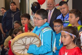 Eskasoni students sing the Honour Song during the grand opening of the Eskasoni Health Centre on Friday, while MP Mark Eyking, back centre left, and Eskasoni Chief Leroy Denny, back centre right, listen intently.