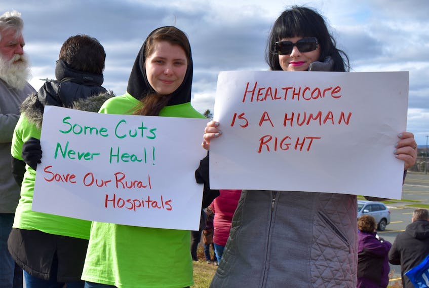 Lauren MacLean, left, from North Sydney and Tracy MacKay from Sydney hold up their signs while waiting for the Save Our Services rally to start. The rally took place outside the Regional hospital on Sunday.