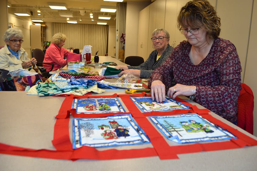 Evelyn MacSween, foreground, a member of the Sydney Breton Quilters, works on a Christmas lap quilt, while enjoying the weekly meeting of the group at the Cape Breton Centre for Craft & Design on Charlotte Street in Sydney, with members, from left, Mary Britten, Arlene Fraser and Sharon Ormond, all of Sydney.