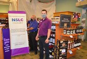 Nova Scotia Liquor Corporation employees in the Glace Bay store, Bill Metcalfe, left, retail product specialist, and Paul Doyle, manager, arrange a sign in the store advising customers of renovations in preparation for the addition of a cannabis store scheduled to open Nov. 30. Fifteen new cannabis stores are opening in existing beverage and alcohol stores across the province, including four in Cape Breton.