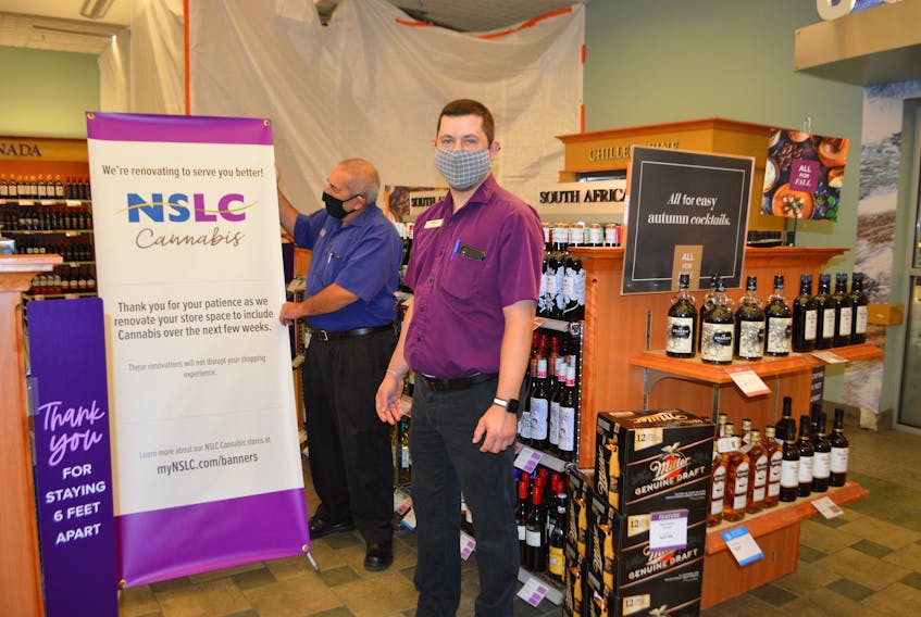 Nova Scotia Liquor Corporation employees in the Glace Bay store, Bill Metcalfe, left, retail product specialist, and Paul Doyle, manager, arrange a sign in the store advising customers of renovations in preparation for the addition of a cannabis store scheduled to open Nov. 30. Fifteen new cannabis stores are opening in existing beverage and alcohol stores across the province, including four in Cape Breton.