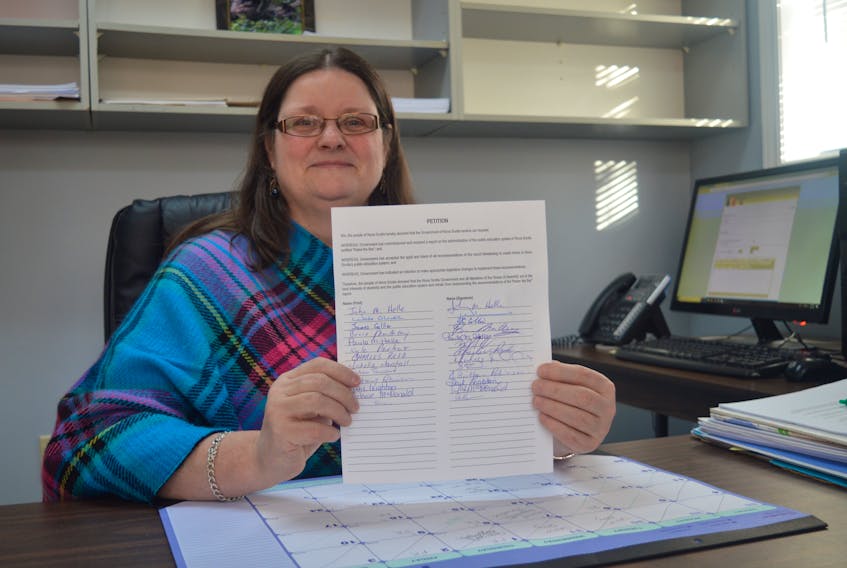 Dayna Enguehard, Cape Breton District local president of the Nova Scotia Teachers Union, displays one of the petitions the NSTU is collecting with signatures of those opposed to the province’s plan to roll out changes to the education system outlined by the Glaze report. The union plans a public forum for Sydney Thursday.