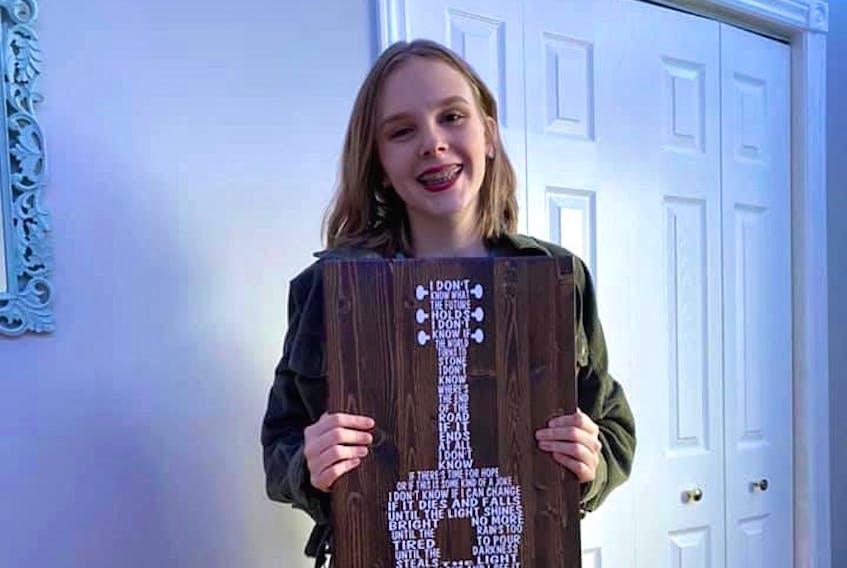 Breagh Kelly, 16, of Glace Bay, holds a handcrafted piece of art she received from a Kings County woman. The stranger was touched after listening to Kelly's song "Guide You Home" which was posted on Facebook following the mass shooting last month.