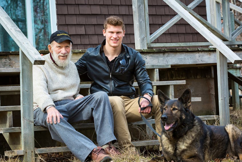 Lloyd Stone, from left, Calvin Kuchta and his dog Arik pose for a photo. Kuchta and Arik, a former police dog, rescued Stone in the woods near Baddeck after the senior fell and broke his hip while cross-country skiing in March 2017. Arik was inducted into the Purina Animal Hall of Fame on Monday.