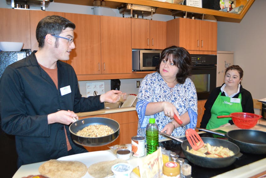 Avery Tremblett, left, dietician for Sobeys, Sydney, chats while cooking apple cheese breakfast quesadillas, a diabetic breakfast, during a free cooking class at the Prince Street store Thursday, Nov. 14, 2019, while getting help from Wallena Hickey, centre, of Sydney, a participant in the class, and Jessica Lemoine, community room coordinator.