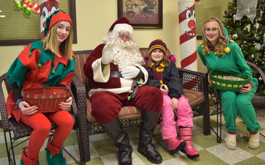 Nine-year-old Jenna Forrestall of Baddeck, second from right, chats with Santa Claus during the Santa in the Park event on Saturday. Santa Claus scheduled the event for Open Hearth Park in Sydney, but weather conditions forced the event to move inside to the Harbourside Place just down the road. From left, Danielle Jessome, Santa, Forrestall, and Madison Bourgeois.
