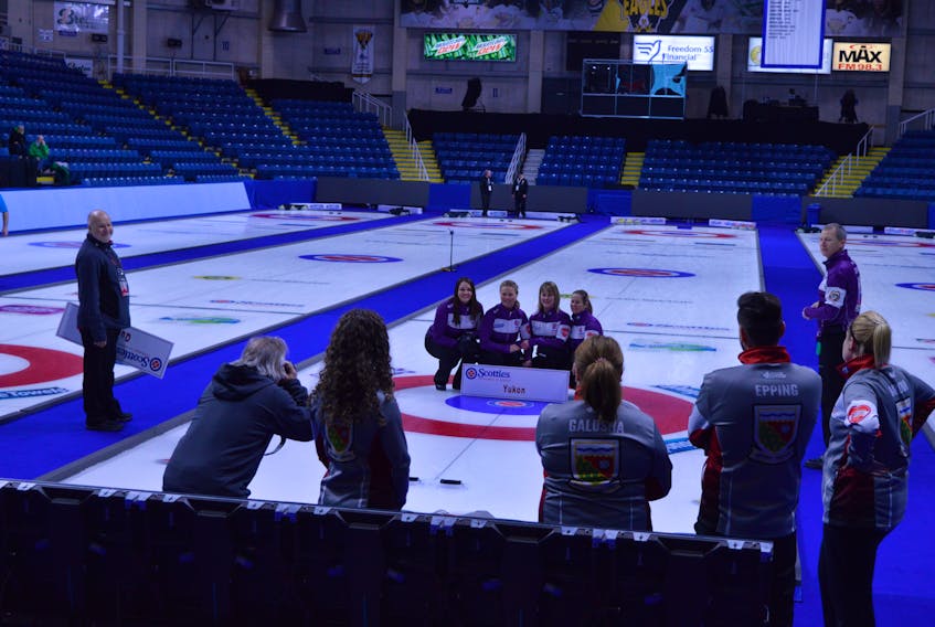 Members of Team Yukon pose for a promotional picture after Friday’s practice while members of the Northwest Territories team look on. Teams posed for photos after their practice sessions.