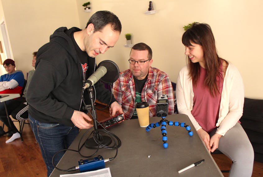 Sydney native Jordan Bonaparte, left, creator of Nighttime Podcast, discusses the equipment he uses for storytelling with Aaron Corbett and Vicky McNeil.
