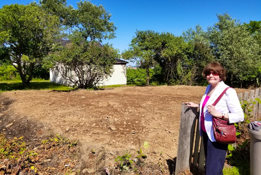 Audrey Currie of Glace Bay stands next to the vacant lot which she took upon herself to clear out. She said the workers did a great job, and was thankful the lilac tree is still standing on the property.