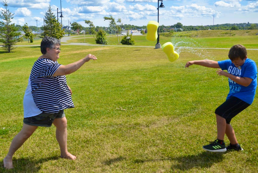Hot day plus kids plus water. It’s a recipe for fun for all ages as the Cape Breton Youth Project demonstrated on Wednesday during a planned water fight using sponges at Open Hearth Park. Here enjoying the fun are Madonna Doucette, left, of the project and Logan King, 9, of Glace Bay.
