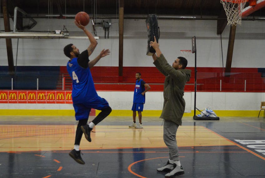 Duke Mondy, left, shoots a jumper as injured Highlanders player Kevin Loiselle plays defence during a Cape Breton Highlanders practice on Friday evening. The Highlanders will play the Niagara River Lions at Centre 200 on Sunday at 2 p.m. CHRISTIAN ROACH/CAPE BRETON POST