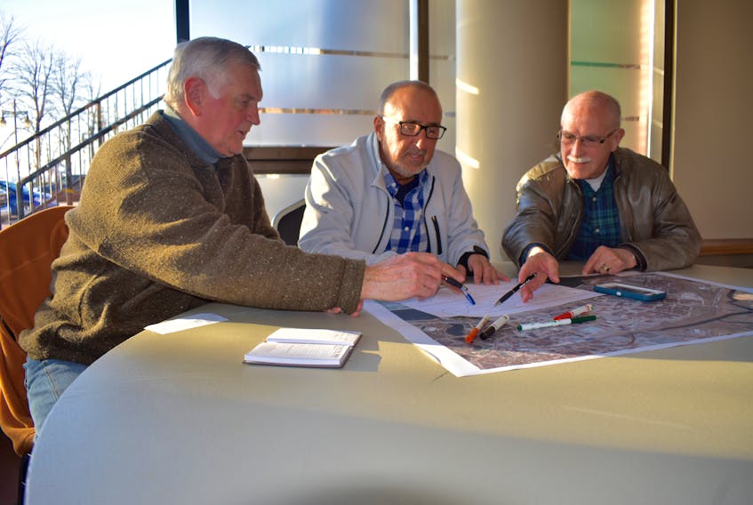 From left, David Young, Craig Boudreau and Bernie Gillis discuss the possible location for the new Nova Scotia Community College Marconi Campus in downtown Sydney. Ekistics Planning and Design held an open house for residents on Wednesday to receive feedback on the design and location for the school.