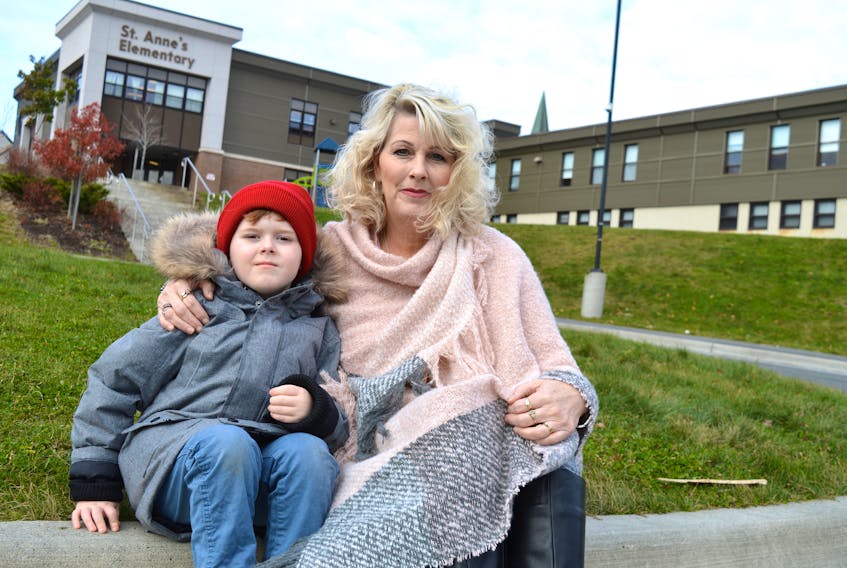 Yvonne MacKenzie sits on the curb outside St. Anne’s Elementary School in Glace Bay with her son, Devon, 5. SHARON MONTGOMERY-DUPE/CAPE BRETON POST