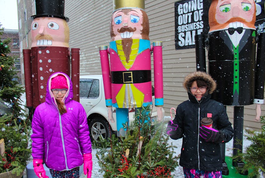 Ryleigh Googoo, left, and her cousin Jada Googoo-Levi stopped for some treats and to visit the giant Christmas decorations on display in downtown Sydney as part of the Nutcracker Festival, which took place Saturday afternoon on Charlotte Street.