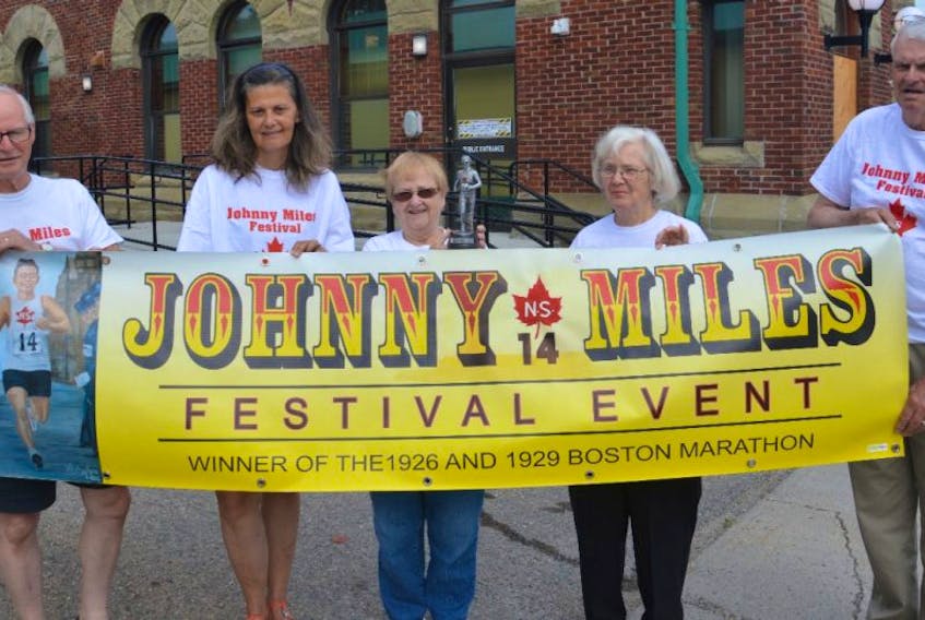 From left, Eugene Ramsey, Kim Rideout, Merdina Bond, Jean Ramsey and Martin Pickup, committee members for the Johnny Miles Festival, are shown holding the festival banner. Plans are well underway for this year’s festival, scheduled for Aug. 3-6 in Sydney Mines.