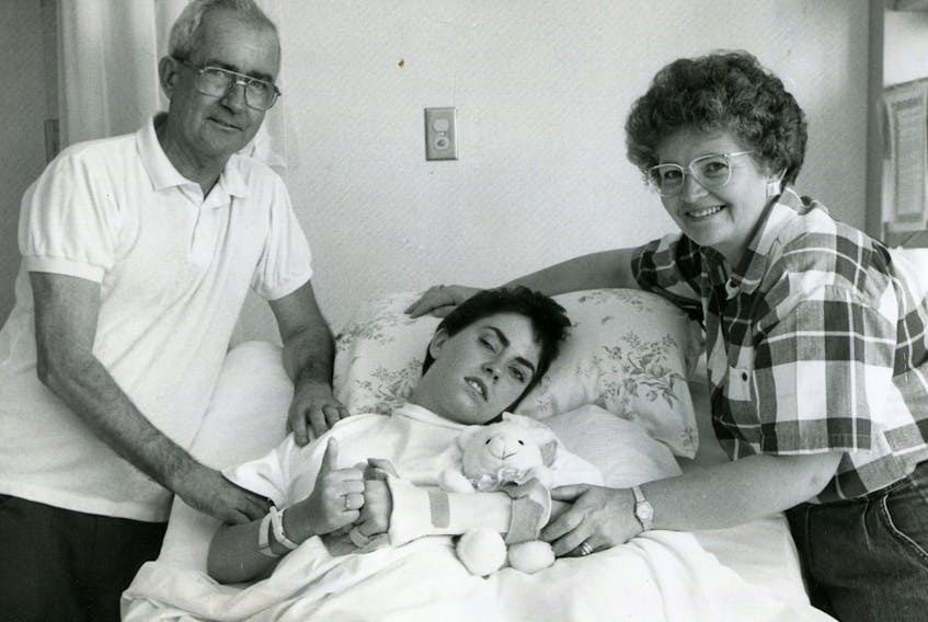 Arleen MacNeil, 20, the lone survivor of a quadruple shooting at the Sydney River McDonald’s restaurant on May 7, 1992, gives a thumbs-up at the Nova Scotia Rehabilitation Centre in Halifax on September 23, 1992. Flanking MacNeil are her parents Howard and Germaine MacNeil of Bras d’Or.