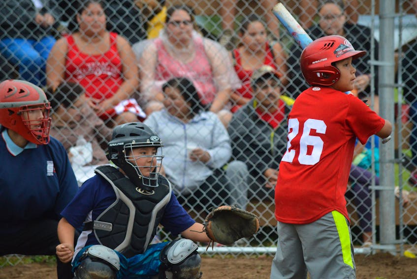 Lucas Michael of the We'koqmaq team waits for a pitch in front of Eskasoni catcher Luther Clair during peewee softball semifinal action at the Charlie Peter Googoo Memorial Ballfield in Wagmatcook during last year’s Nova Scotia Mi'kmaw Summer Games. This year’s edition of the Games opens Sunday in Eskasoni.