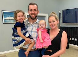 Cyril MacDonald, 27, takes a photo with his wife, Kailin Keigan, and their daughters Zoey (in his arms) and Quinnleigh after winning the seat for District 3 in the Cape Breton Regional Municipality's 2020 election. MacDonald waited for results at the Georges River Fire Hall with family, friends and supporters.