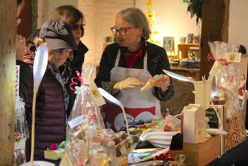 Chocolatier Penny Steele, right, talks to a customer about the ingredients she uses in her hand-crafted sweets during the Deck the Halls Christmas Fair held at St. Patrick's Church Museum in Sydney on Sunday. Steele was there with Deb Karn, her partner in their Cabotto Chocolates business located along the Cabot Trail in Indian Brook, Victoria County. This is the fourth year for the fair, which provides local artisans a place to sell their goods while raising money for charity. Organizer Joan MacKenzie, owner of Needle It Studio, said this year's charity recipient is Women of Hope, which raises money for hospice care