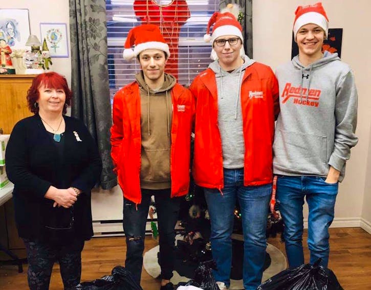 Last week, the Riverview Redmen and their families, collected donations for the Every Woman's Centre in Sydney. Members of the Redmen recently presented the donations to Wanda Earhart of Every Woman's Centre. From left, Earhart, Kendall MacQueen, Rylan MacIntyre and Ethan Stanwick.