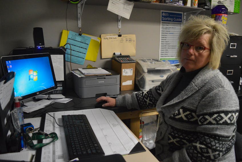 Kathy Timmons, manager of Triple B Recycling, sits at the desk in her office. The computer was compromised during a cyber crime attack and the business account drained of all money.