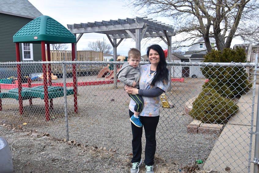 Melissa Campbell, an early childhood educator at Mini Miners Daycare and Preschool, holds her two-year-old nephew, Jaxson Digero, outside the child-care centre in New Waterford.