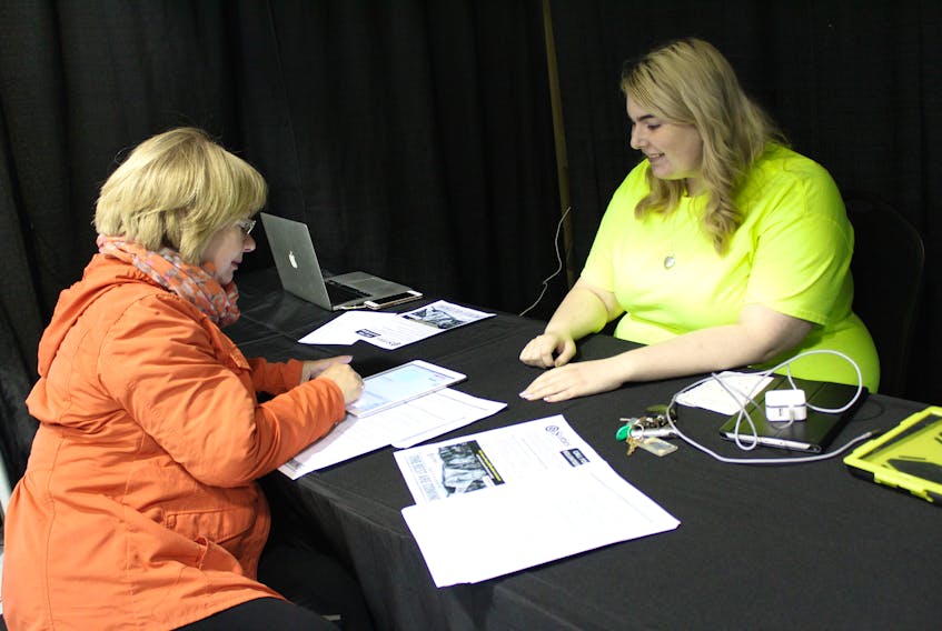 CBRM summer student Brooklyn Galbraith, right, helps Theresa Johnstone of Howie Centre complete her application to become a volunteer with the Scotties Tournament of Hearts women’s curling championship that will be taking place in Sydney in February.