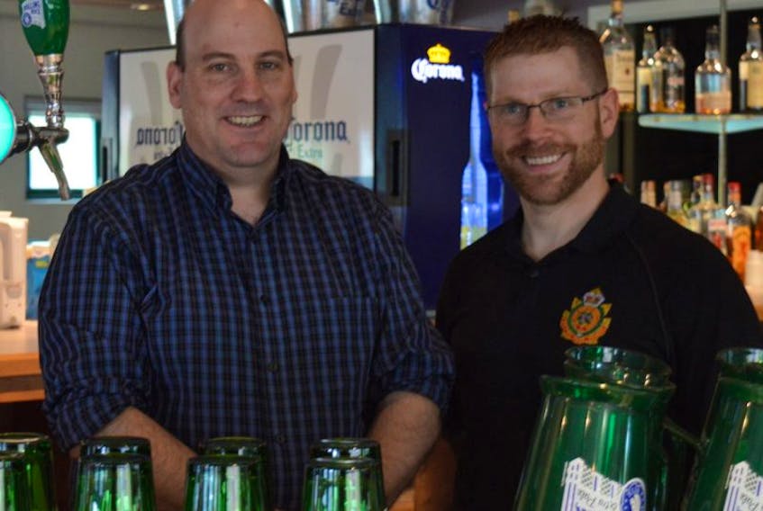 Colin Rankin and Capt. John Boudreau stand behind the bar at the Victoria Park officers mess during a Father’s Day social.