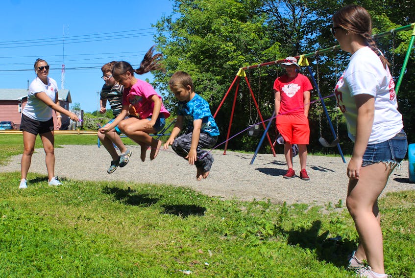 Holly Slade, far left, and Tesa Ramsay, far right, hold the skipping rope while, from left, Jett Archibald, Nevaeh Ogley, and Owen Ogley get some air under them while jumping rope Thursday morning.