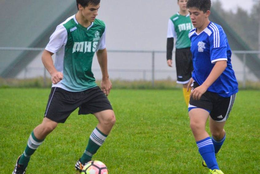 Jacob Johnston of the Memorial Marauders, left, is challenged by Justin Ferguson of the Sydney Academy Wildcats during Cape Breton High School Soccer League play Monday at Memorial field in Sydney Mines. The Wildcats won the match, 7-1.