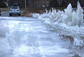 Doug Thorne stops to take a photo of the ice along a section of Blacketts Lake Road during his morning walk on Dec. 18. The ice formed during the wind storm on Dec. 16 which blew water across the road, leaving frozen branches, rocks and gravel on both sides. Some of the ice formations look like schools of jellyfish swimming together. Others look as if the water froze in mid-air as the wind tossed it from the lake. Thorne, who's lived in Howie Centre his whole life, said he walks the route regularly and like others who stopped in their cars to take a look, was amazed at the sight. "In all my years of living here, I've never seen anything like this here before," he said before resuming his workout. "I've never seen the water blow right across the road before."